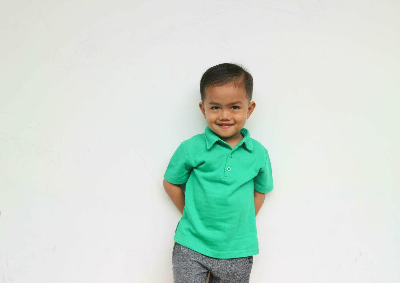 Portrait of a cute little Asian boy looking at camera and smiling, on the white background photo