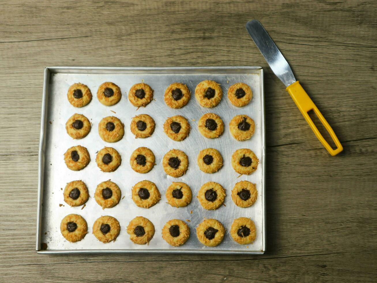 Cheese Thumbprint Cookies with Chocolate Filling, thumbprint cookies fresh from the oven on the aluminum pan photo