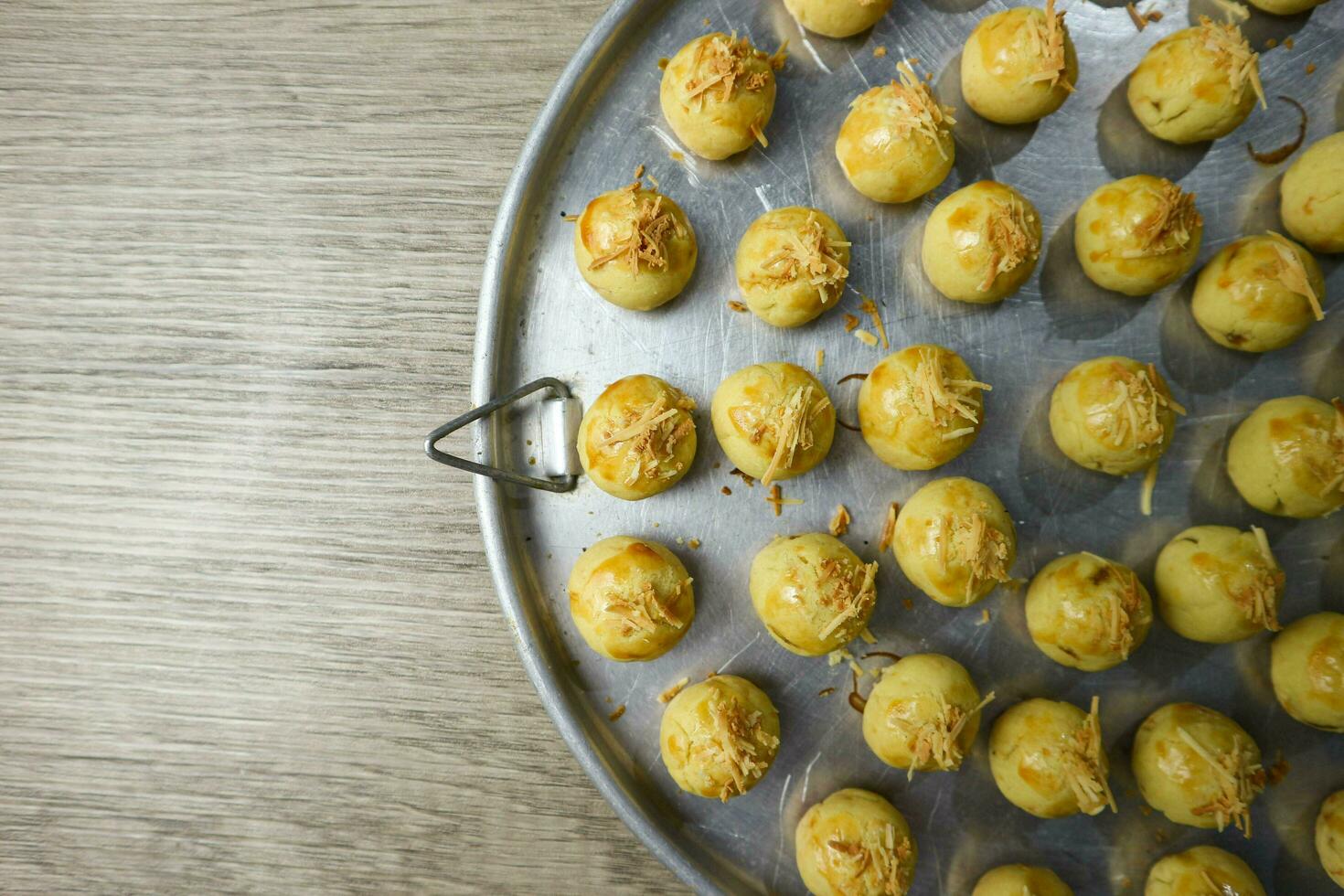 Nastar Keju. Homemade Pineapple Tart or Nastar Keju, cookies with pineapple jam filled and spread grated cheese on the aluminium pan, fresh from the oven. Served during Eid Al Fitri photo
