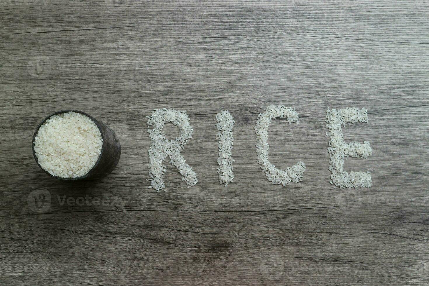 Rice, rice grains form RICE lettering on the wooden background photo