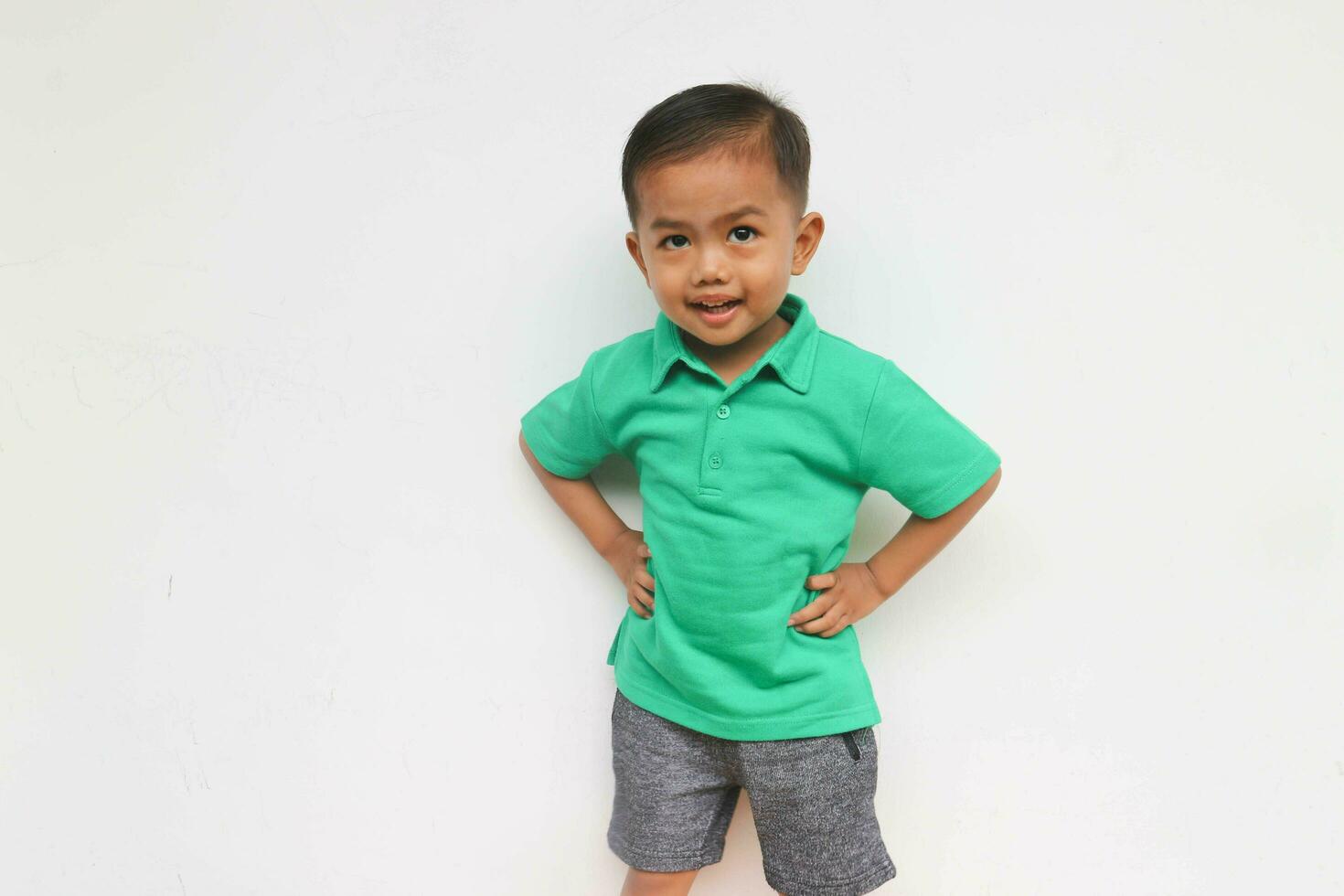 retrato de un linda pequeño asiático chico mirando a cámara y sonriente, en el blanco antecedentes foto