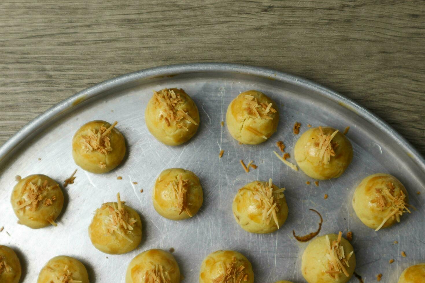 Nastar Keju. Homemade Pineapple Tart or Nastar Keju, cookies with pineapple jam filled and spread grated cheese on the aluminium pan, fresh from the oven. Served during Eid Al Fitri photo