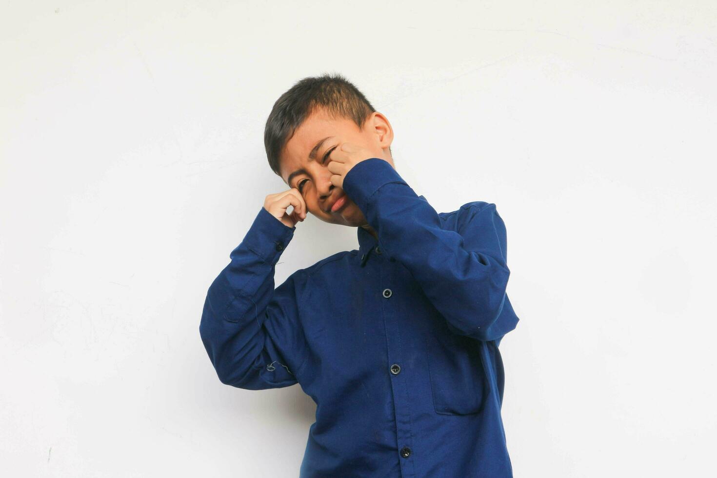 Sad boy wearing blue shirt isolated on white background photo
