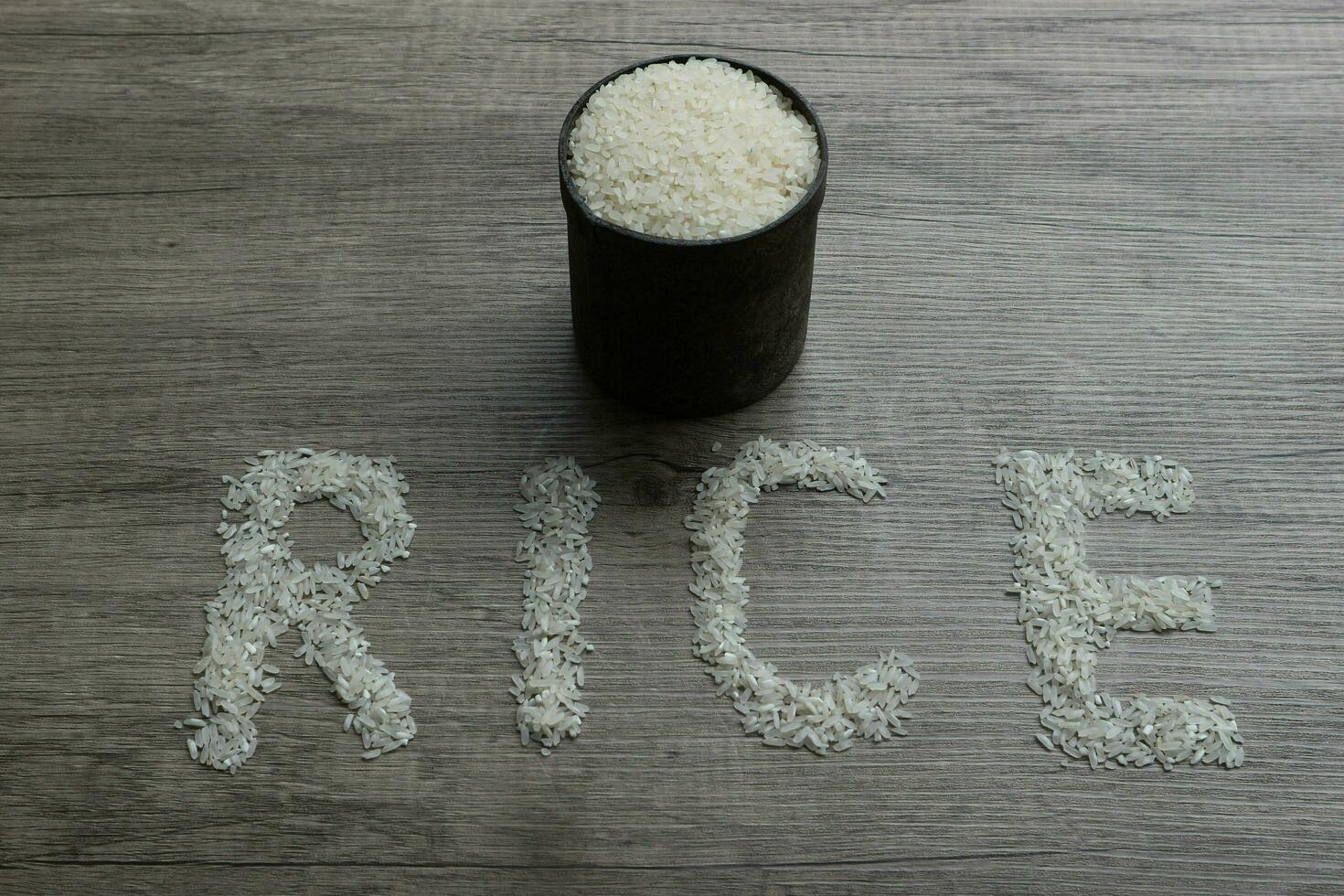 Rice, rice grains form RICE lettering on the wooden background photo