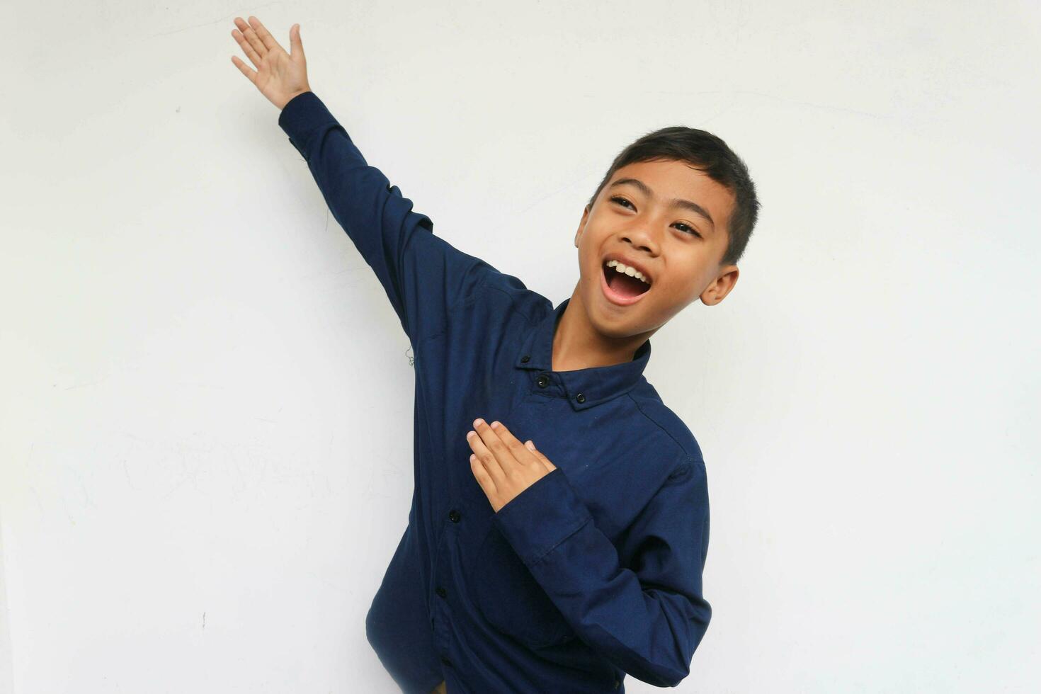 Happy Asian boy hands up raised arms from happiness isolated on white background, Excited kid winner success concept photo