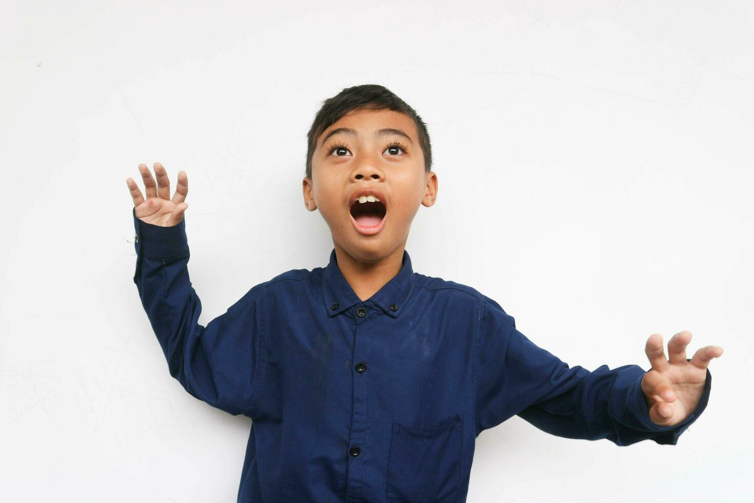 Surprised boy wearing a blue casual shirt Isolated on white background photo