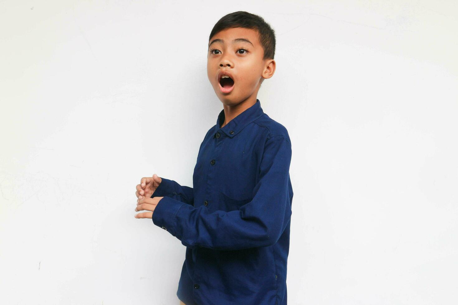 Surprised boy wearing a blue casual shirt Isolated on white background photo