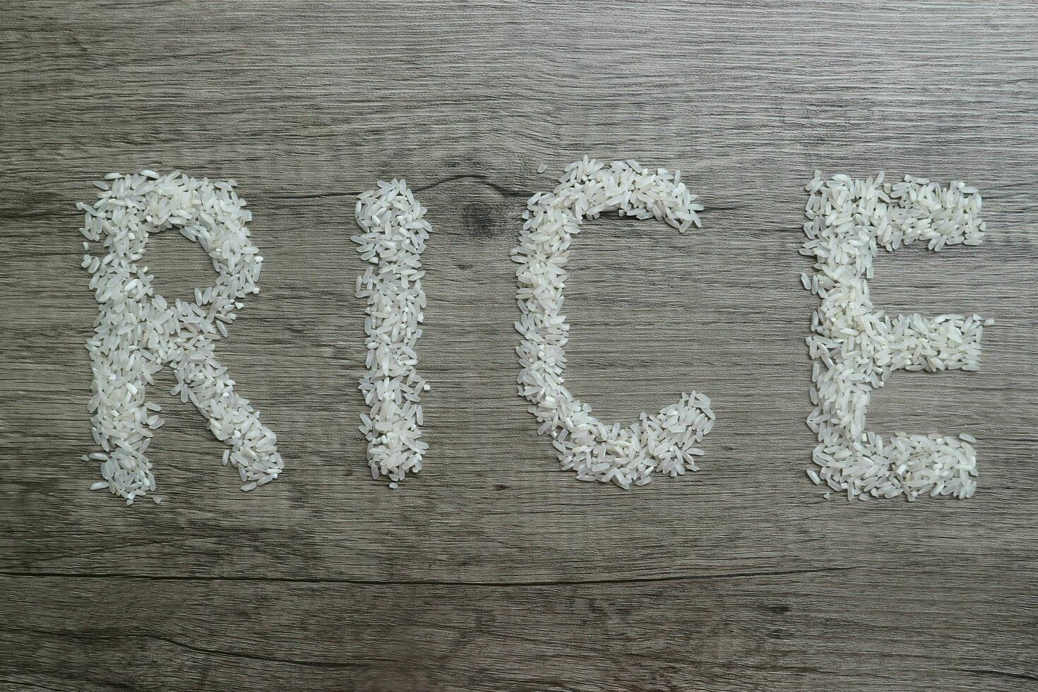 Rice, rice grains form RICE lettering on the wooden background photo