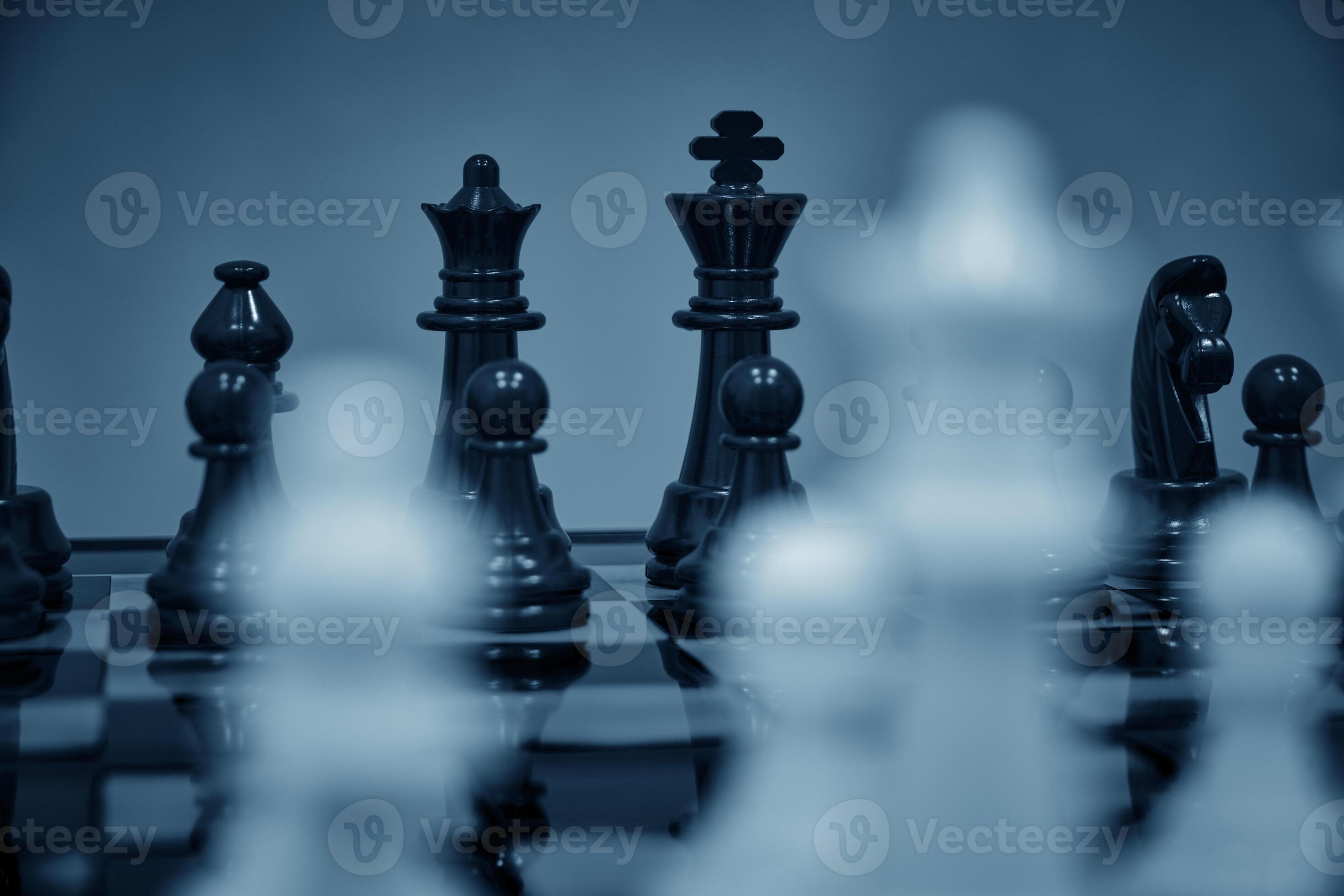 Premium Photo  Closeup of chess pieces on the chessboard under the lights  with a blurry background