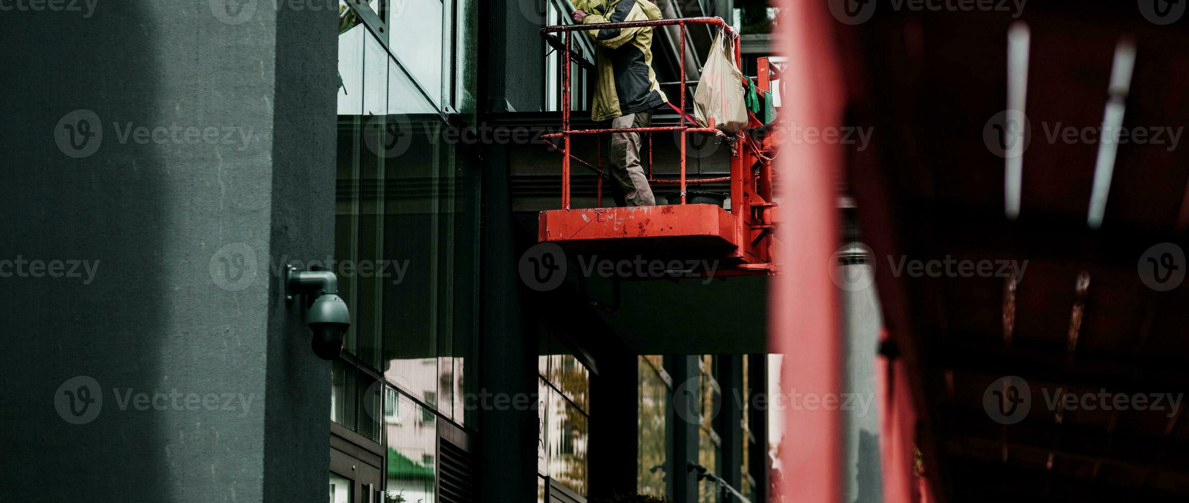 Female window cleaner cleaning glass windows on modern building photo
