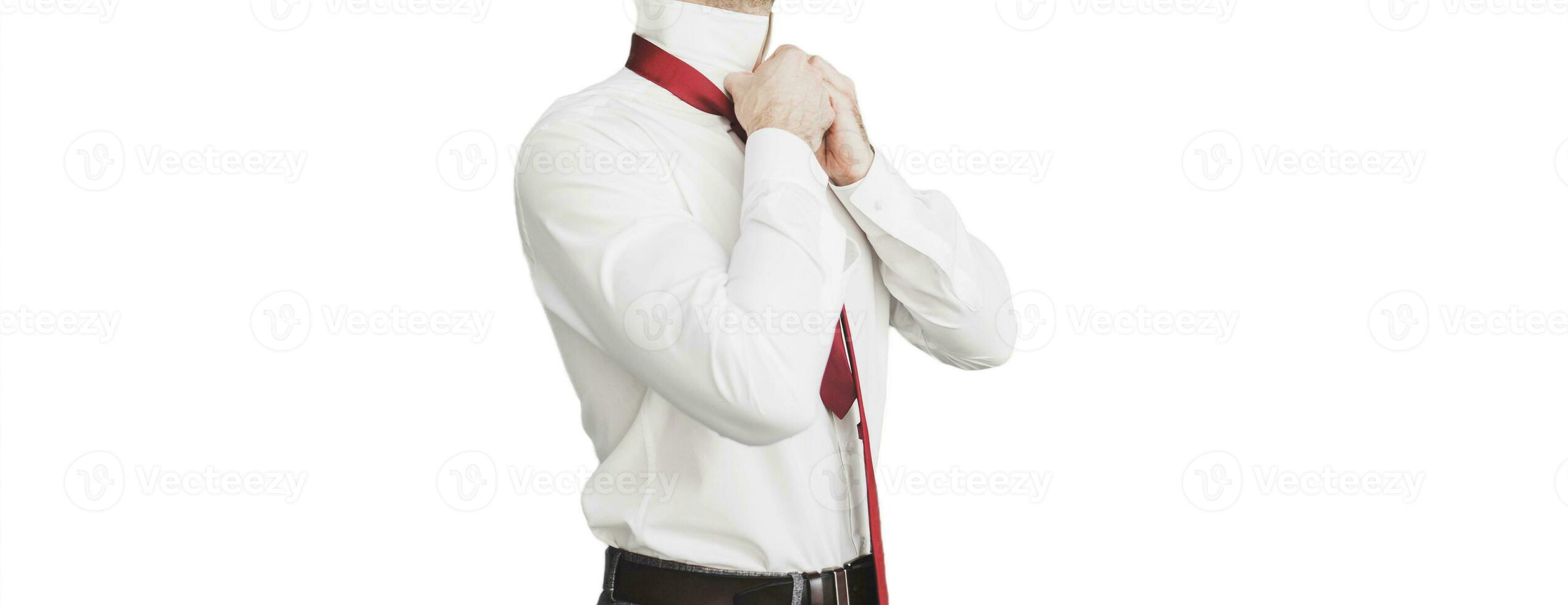 groom straightens his shirt on white background photo