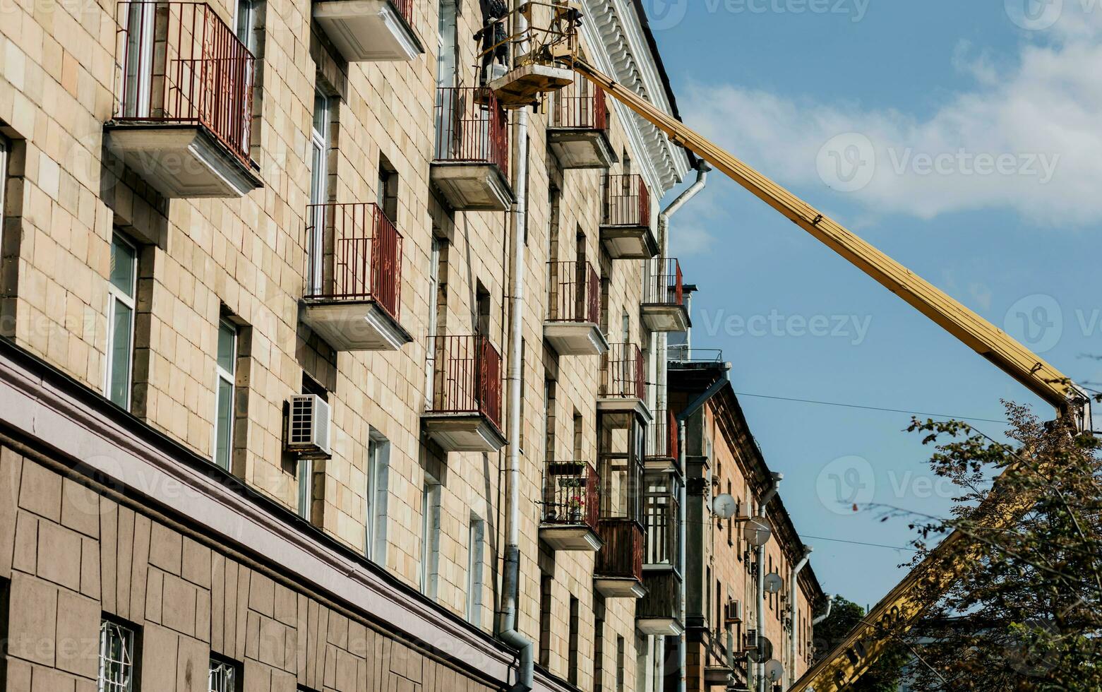 Construction workers at height working on crane in lifting bucket. photo