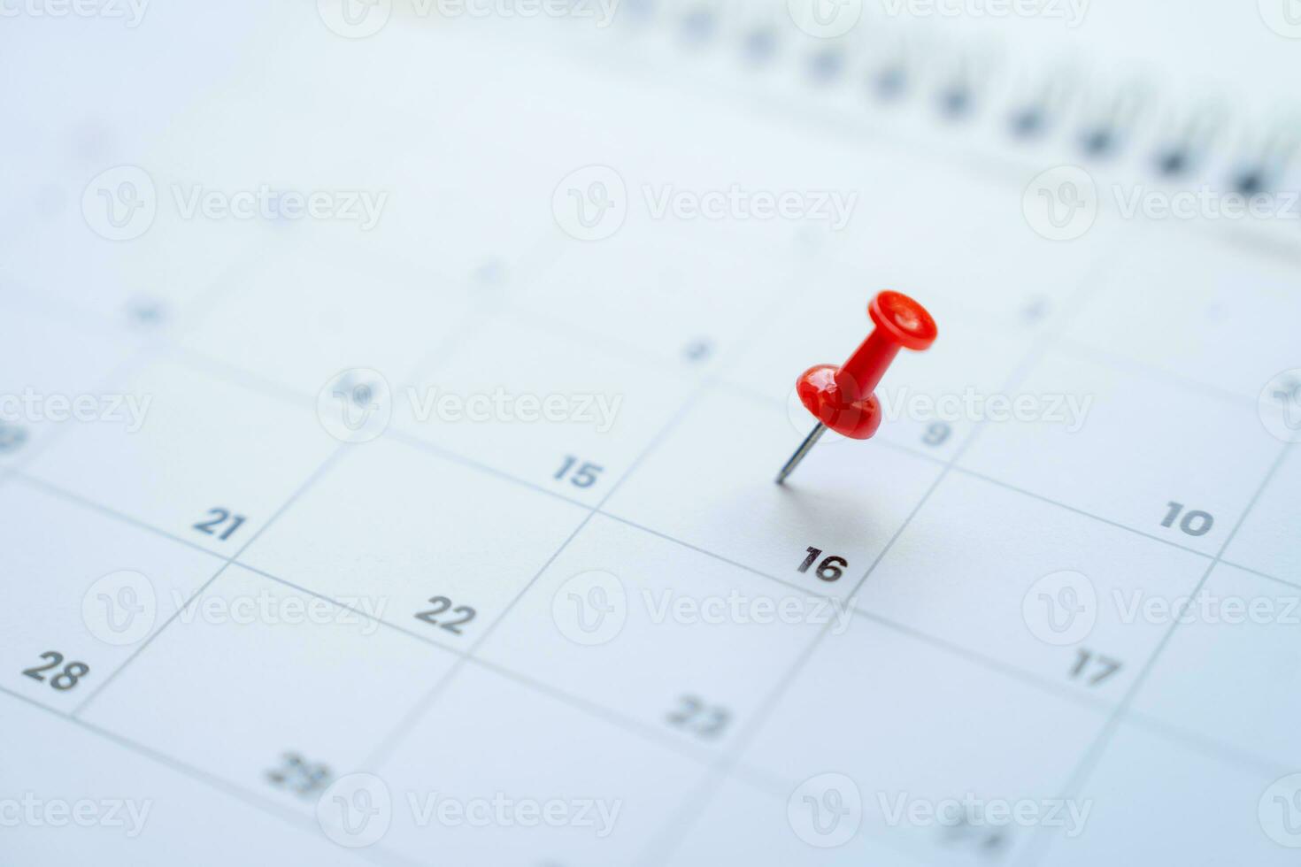 Red pin on the 16th day on the calendar, appointments and meeting reminders. photo