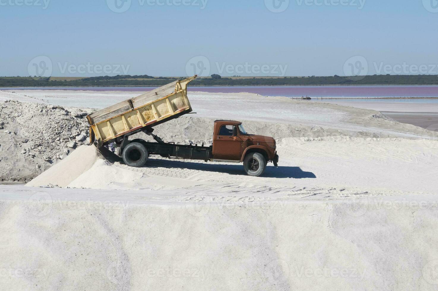 Trucks unloading raw salt bulk, Salinas Grandes de Hidalgo, La Pampa, Patagonia,  Argentina. photo