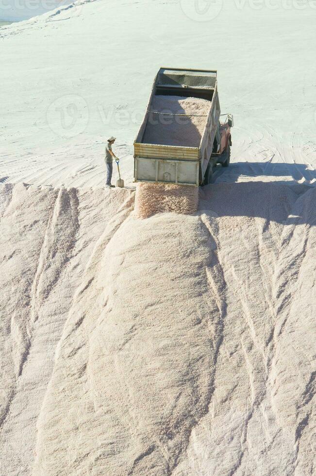 Trucks unloading raw salt bulk, Salinas Grandes de Hidalgo, La Pampa, Patagonia,  Argentina. photo