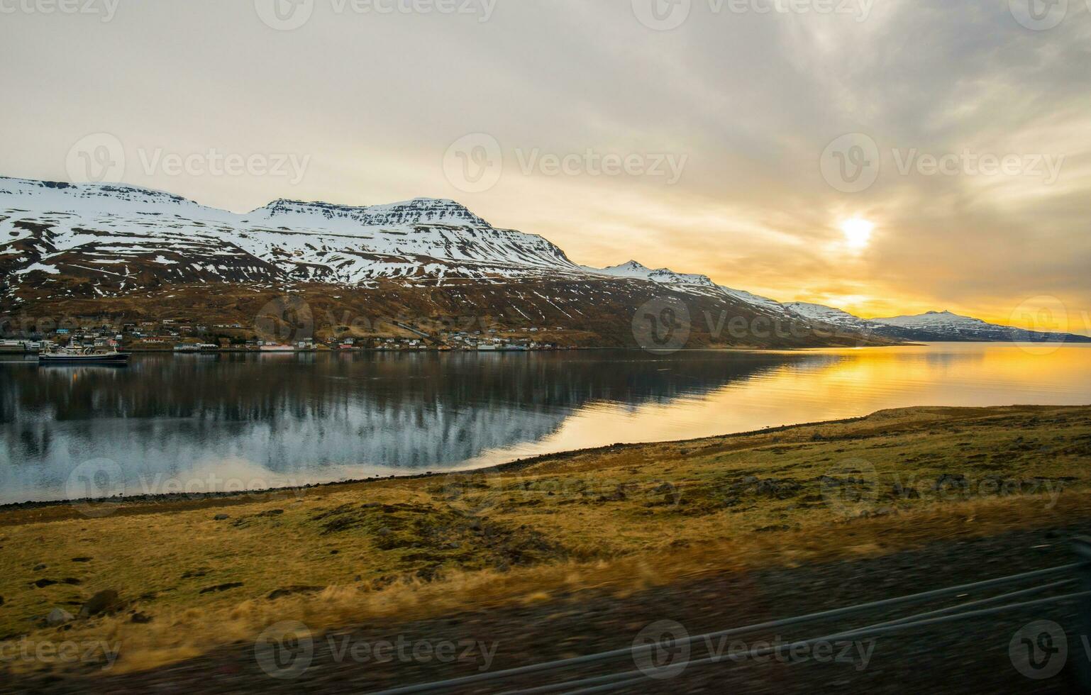 The scenery view of snowcapped mountains range in the fjord of East Iceland during the sunrise. photo