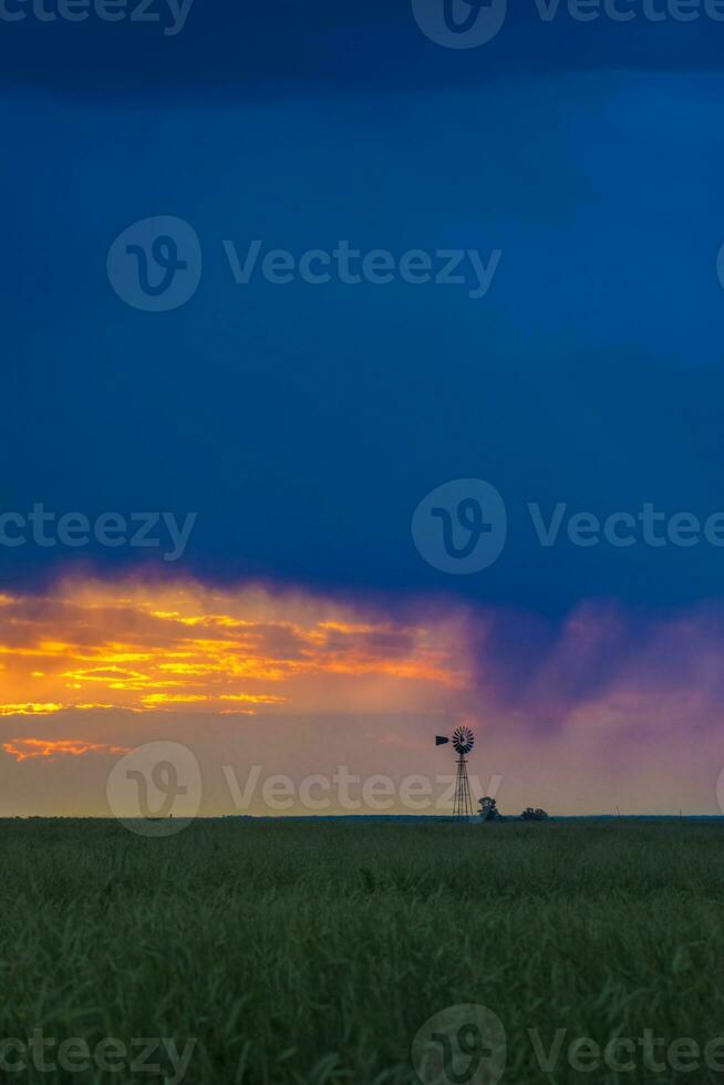 Pampas windmill landscape at sunsetin storm, La Pampa Province,  Argentina photo
