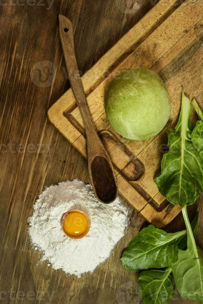 Green dough bun for noodles with ingredients on the table. photo