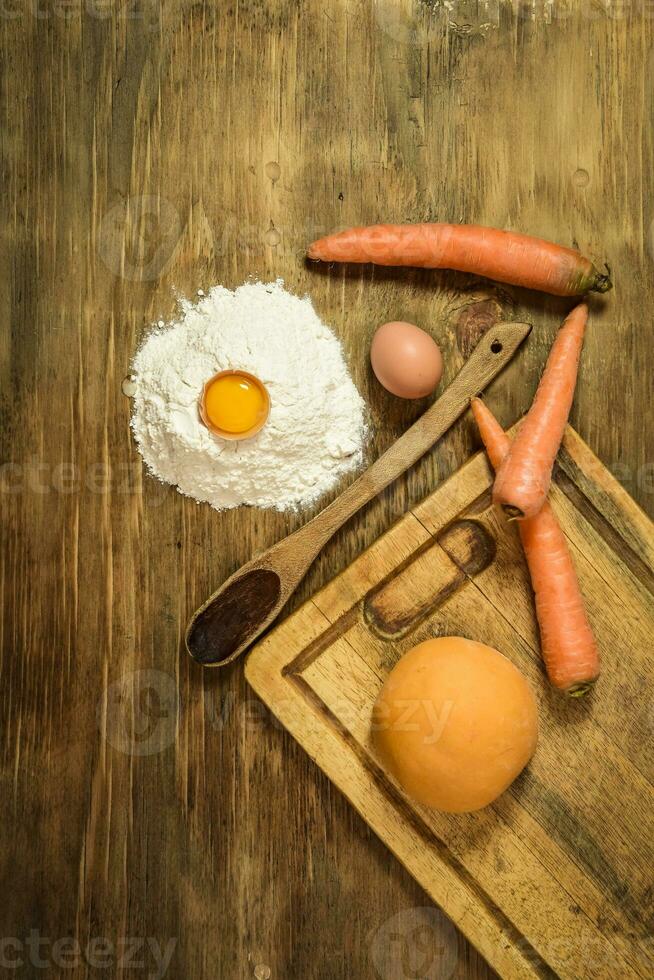 naranja masa bollo para tallarines con ingredientes en el mesa. foto