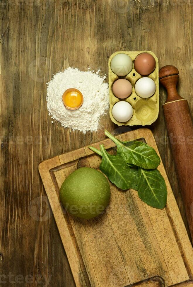 Green noodle dough bun, with ingredients on the table. photo