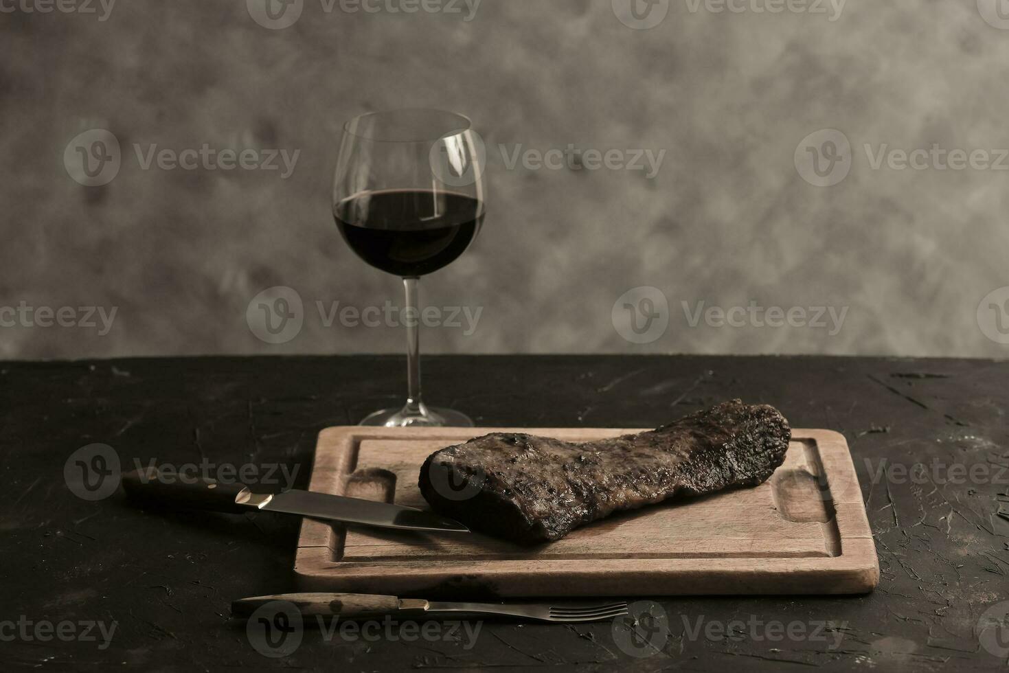 Roasted beef ribs with a glass of red wine presented on the table, traditional Argentine cuisine, Asado barbecue, Patagonia, Argentina. photo