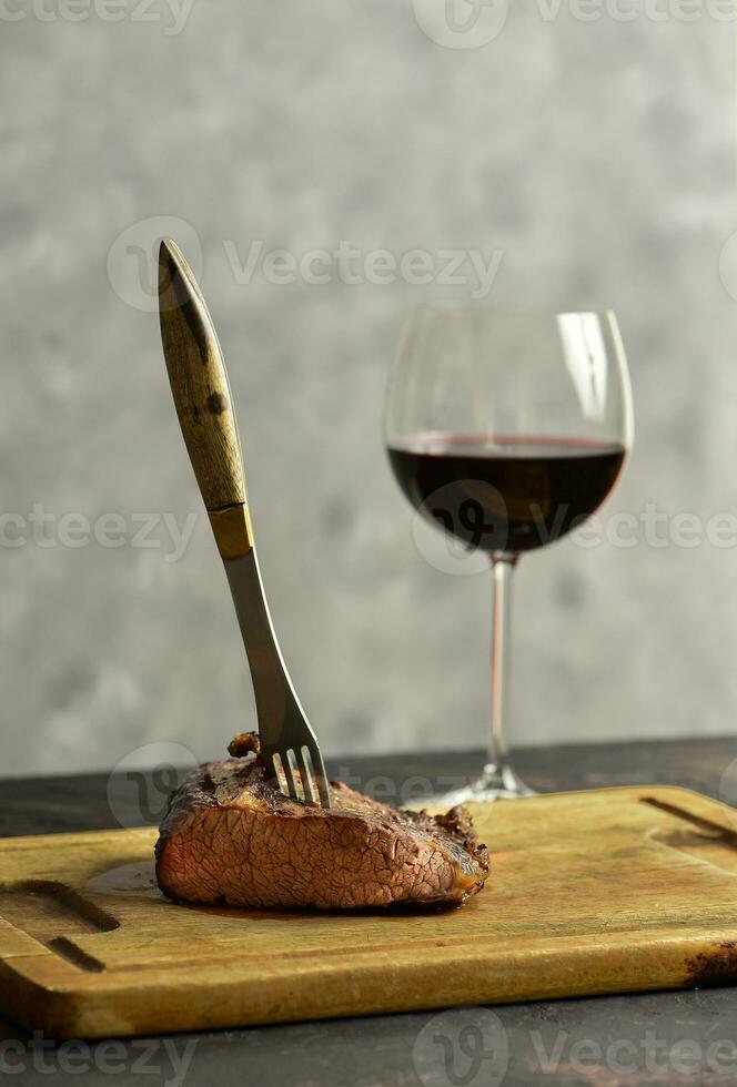 asado carne de vaca costillas con un vaso de rojo vino presentado en el mesa, tradicional argentino cocina, asado parilla, Patagonia, argentina. foto