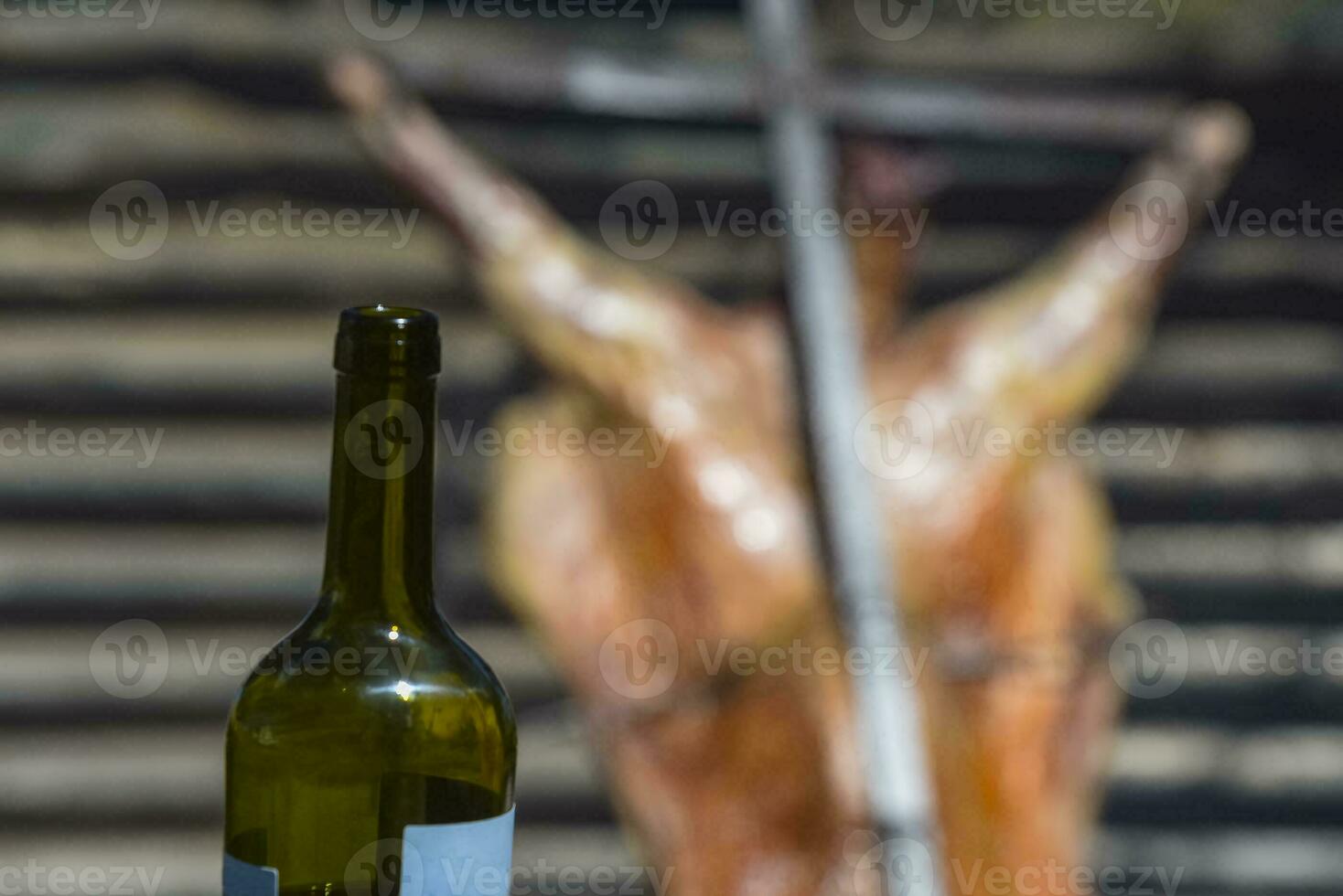 Bottle of wine with roast lamb in the background photo