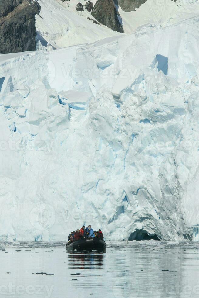 Tourists watching a glacier in Antarctica, near the Antarctic Peninsula. photo