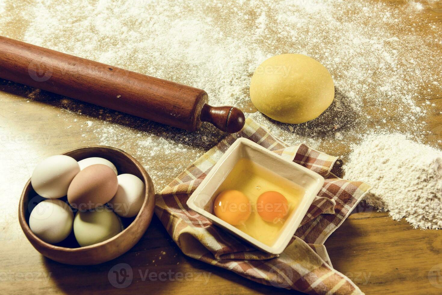 Yellow dough with ingredients on the table, homemade italian food. photo