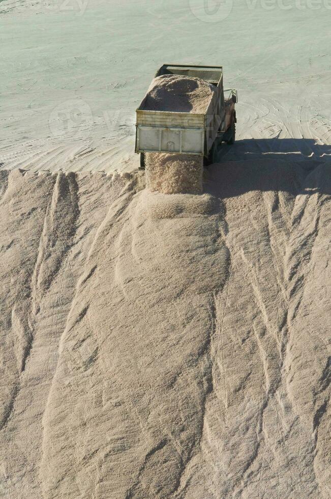 Trucks unloading raw salt bulk, Salinas Grandes de Hidalgo, La Pampa, Argentina. photo