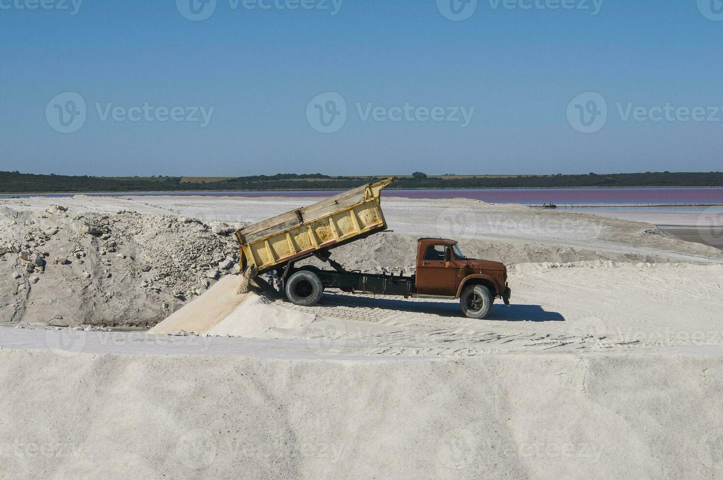 Trucks unloading raw salt bulk, Salinas Grandes de Hidalgo, La Pampa, Patagonia,  Argentina. photo