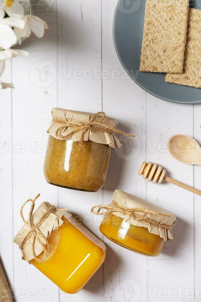 Jars with honey and nuts honey on wooden background top view, flat lay photo