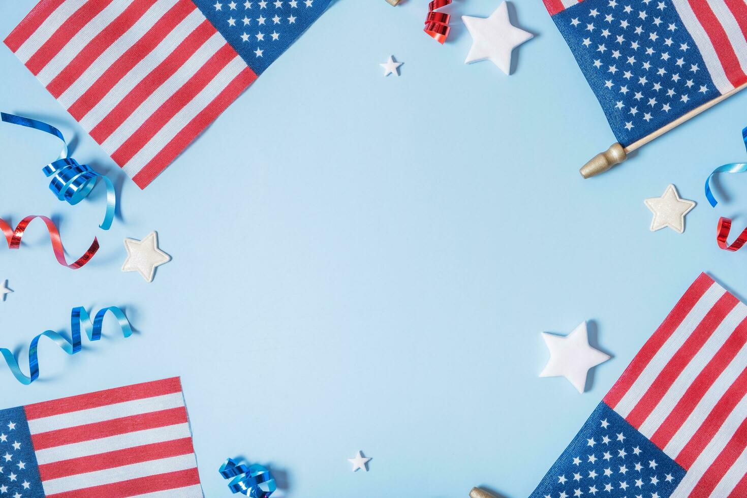 USA Independence day concept. USA flags and Red and blue spirals and white stars top view, flat lay on blue background with copy space photo