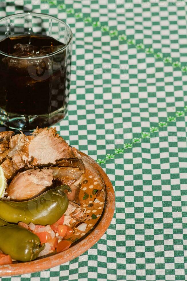 The Mexican carnitas, a delicious food, is served with various condiments on a table with tableware photo