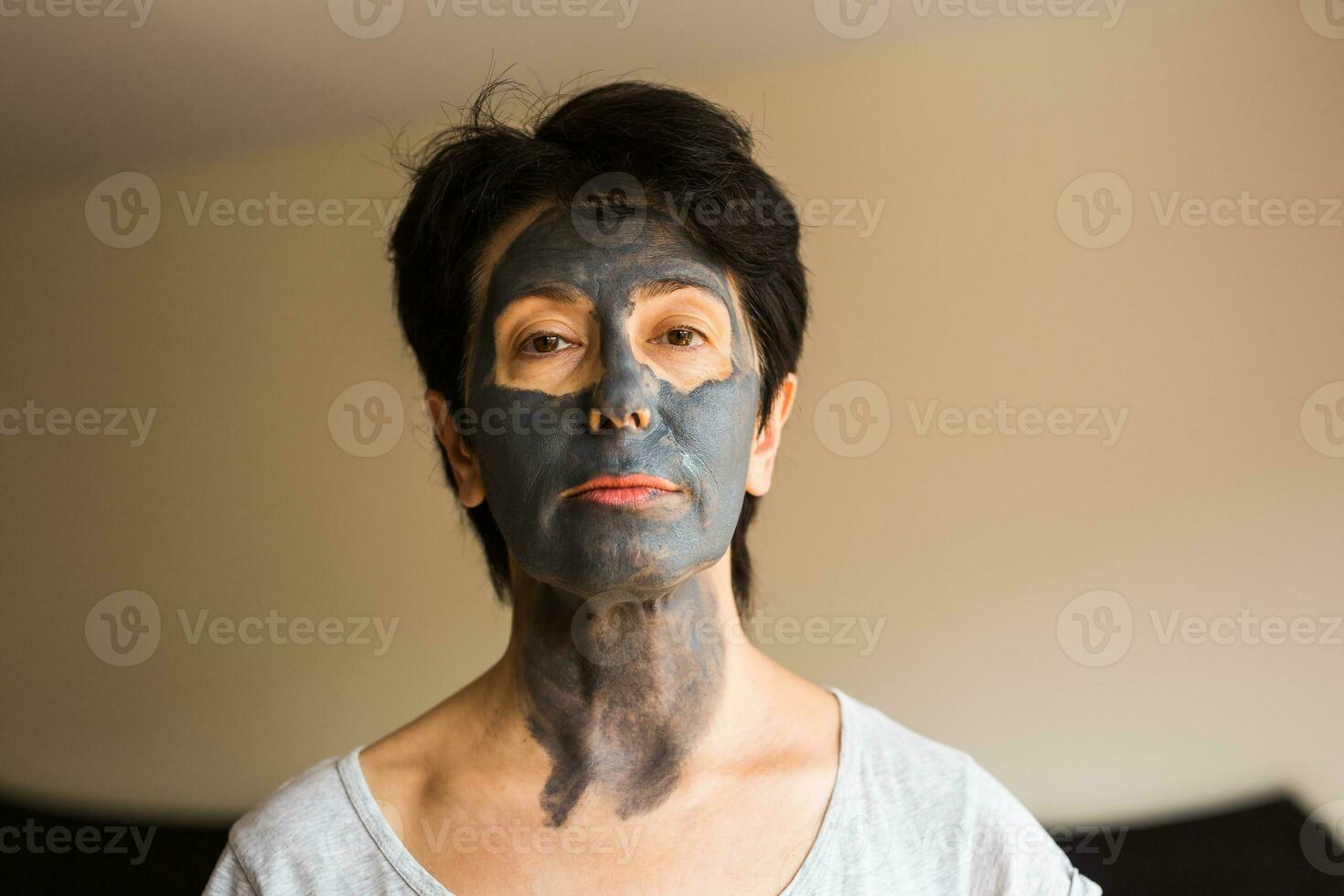 Beautiful woman with facial mask. Cosmetology, spa, skin care and people concept. photo