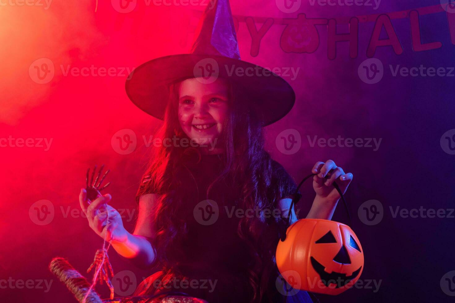 Little witch child cooking potion in the cauldron on Halloween. photo