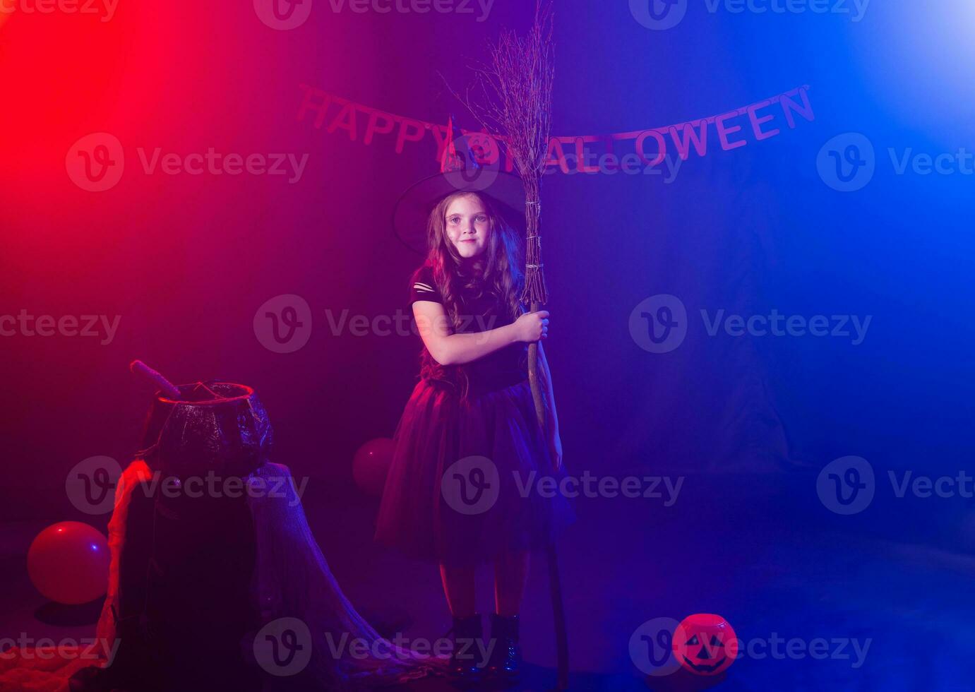 Funny child girl in witch costume for Halloween with pumpkin Jack and broom. photo