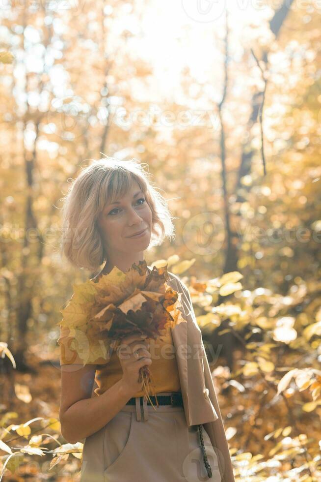 Autumn woman in fall season park. Warm sunny weather. photo