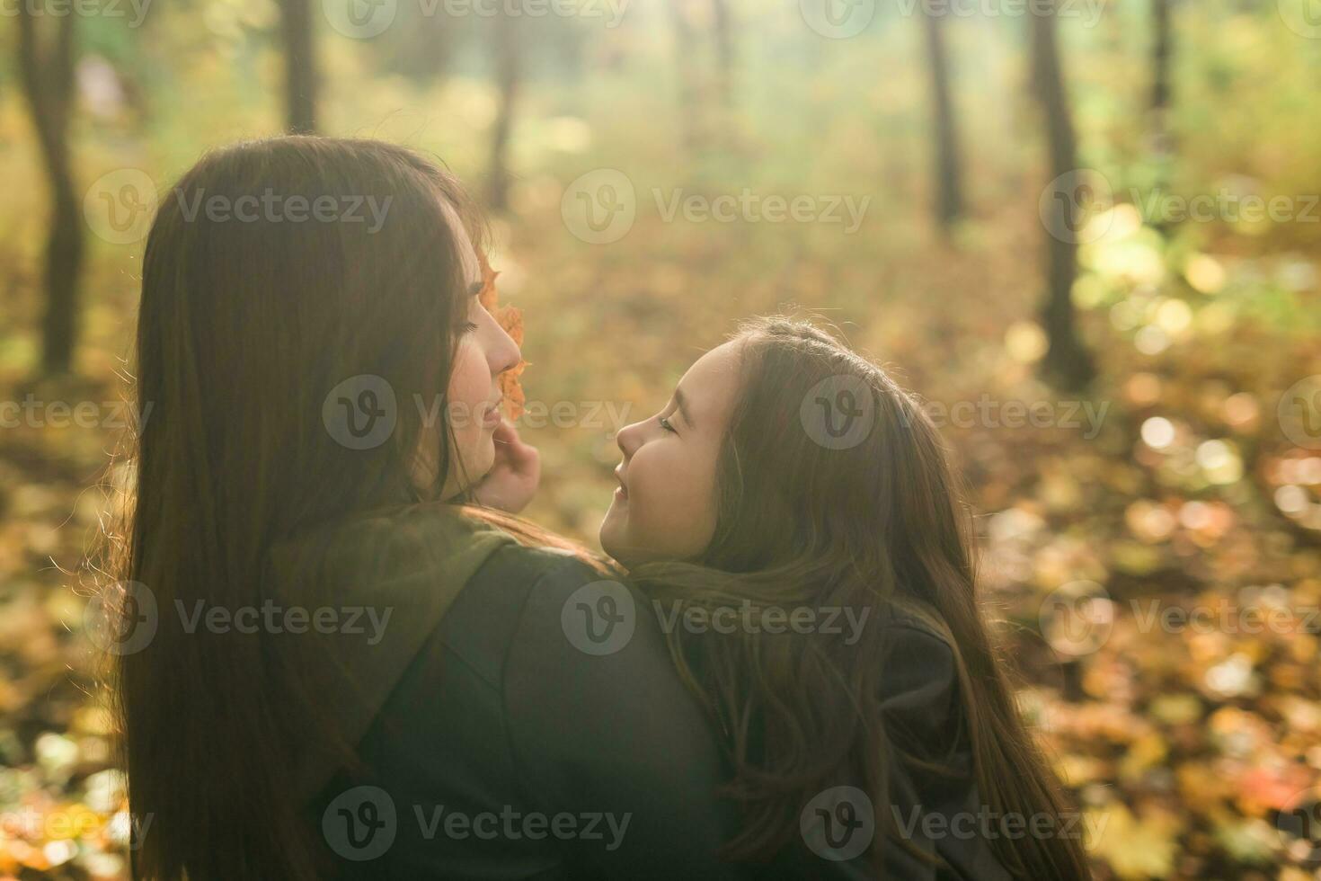 madre y hija gastar hora juntos en otoño amarillo parque. temporada y soltero padre concepto. foto
