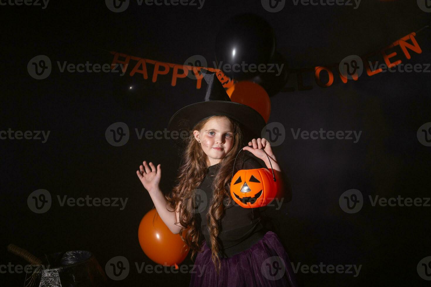 gracioso niño niña en bruja disfraz para Víspera de Todos los Santos con calabaza Jacobo. foto