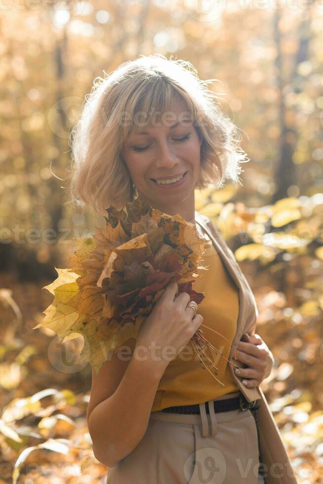 Portrait of beautiful young woman walking outdoors in autumn. Fall season and stylish girl concept. photo