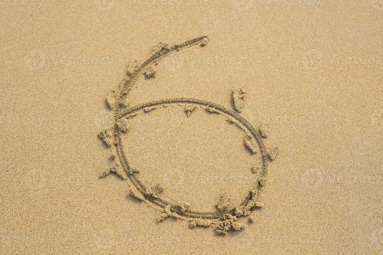Six number written on sand on summer beach photo