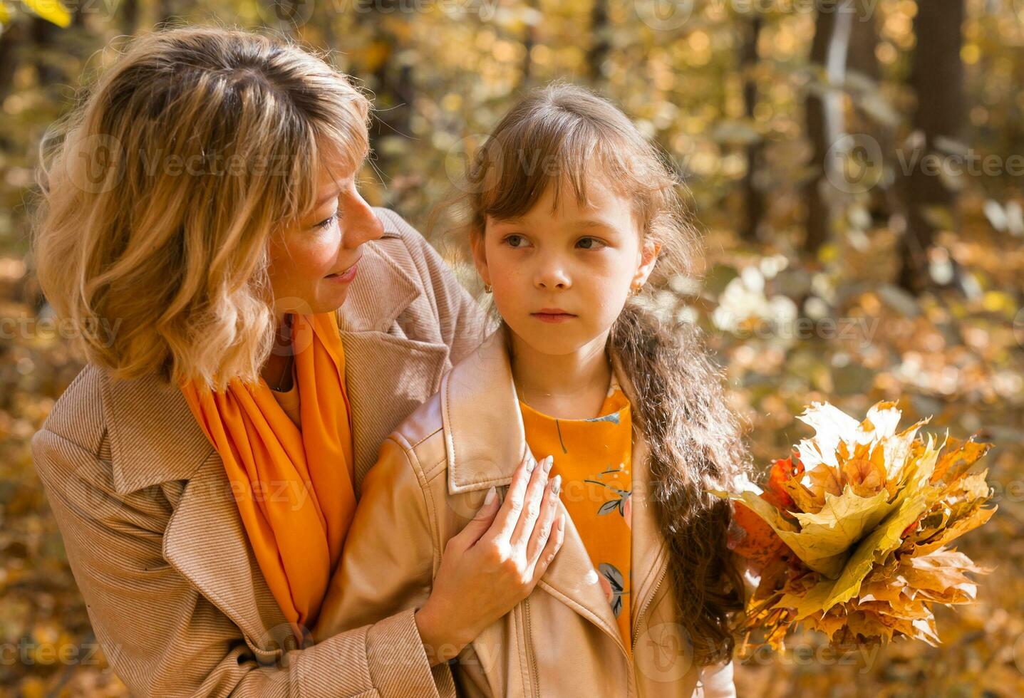 madre calma su infeliz triste hija en otoño naturaleza. niños depresión concepto foto