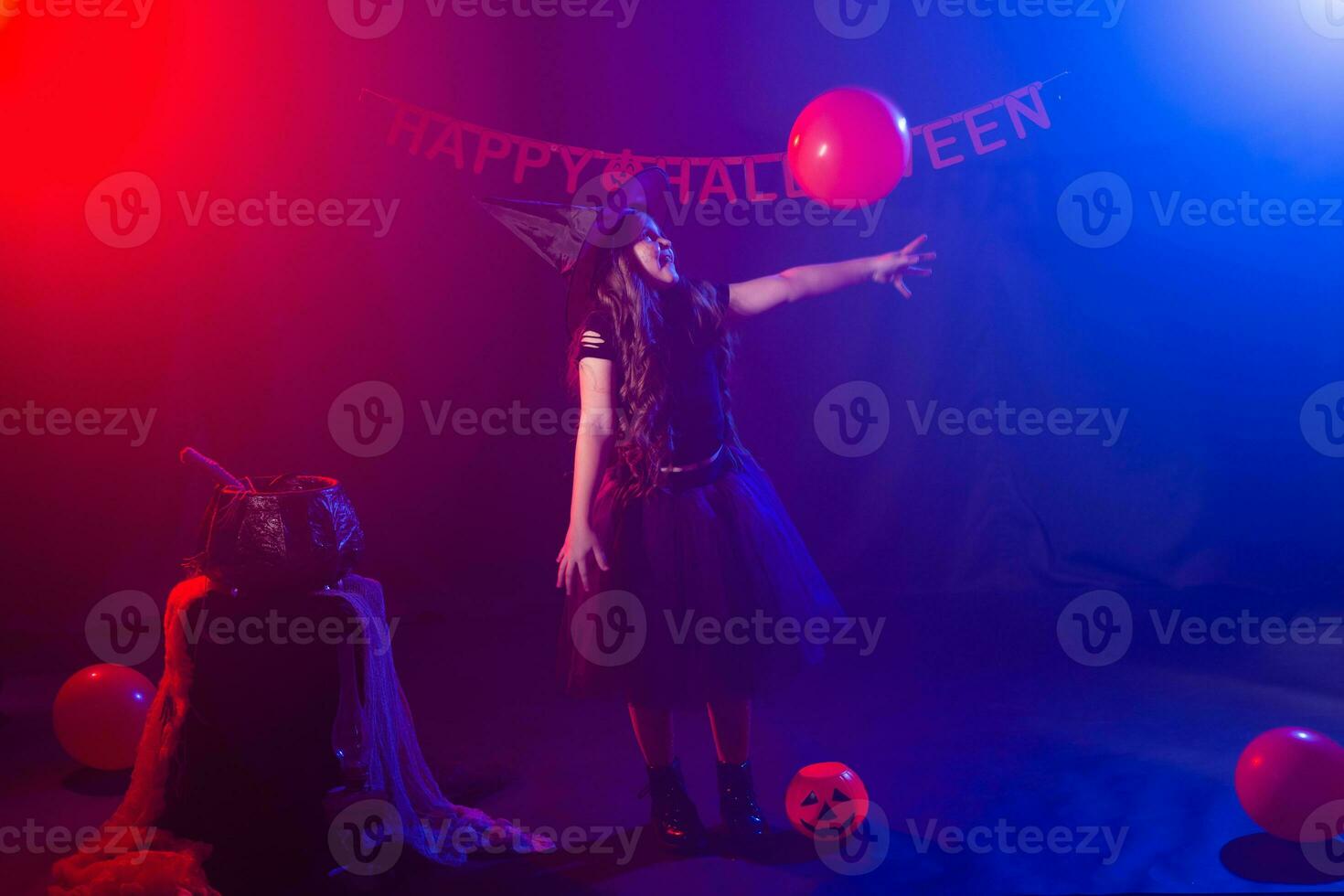 Funny child girl in witch costume for Halloween with pumpkin Jack. photo