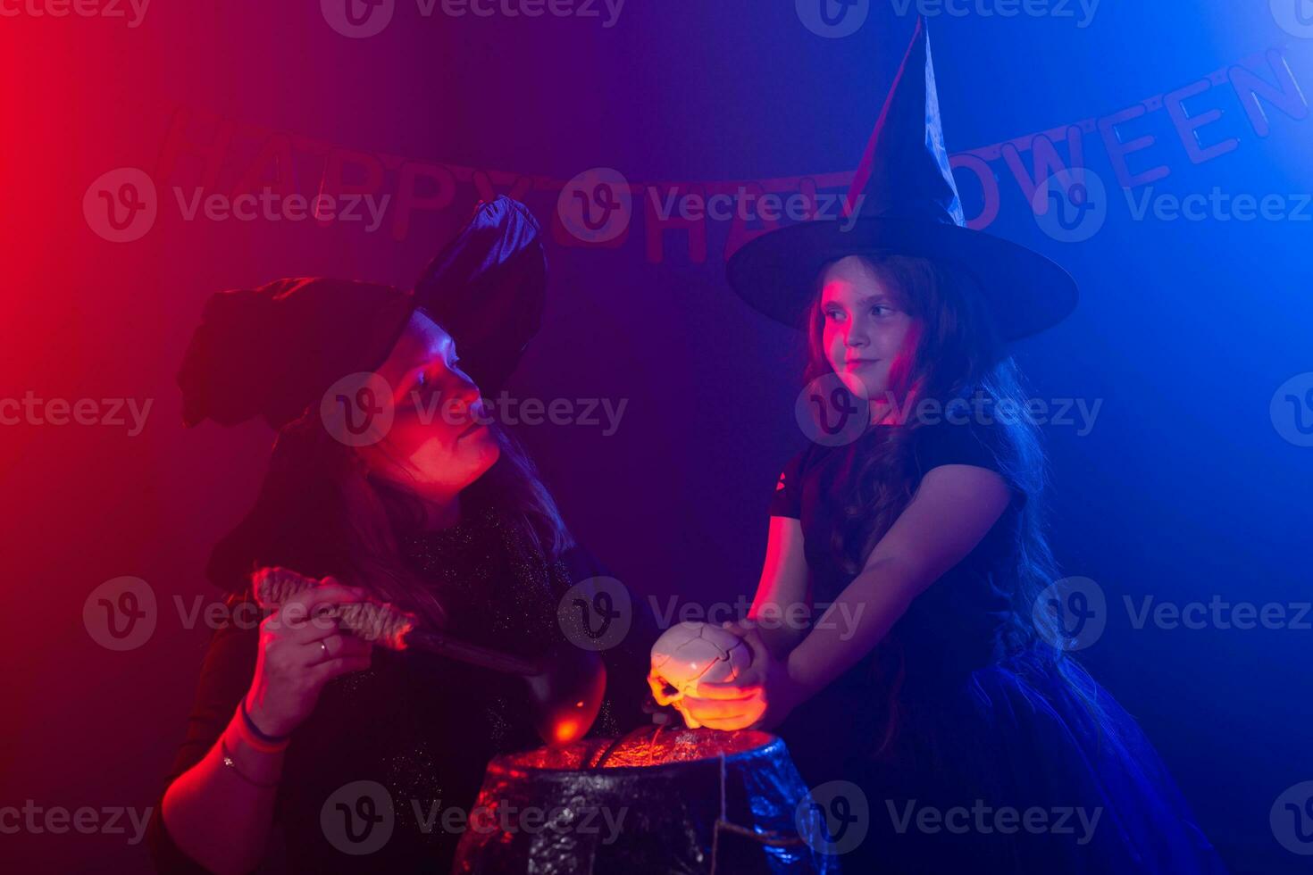 Funny child girl and woman in witches costumes for Halloween with pumpkin Jack. photo