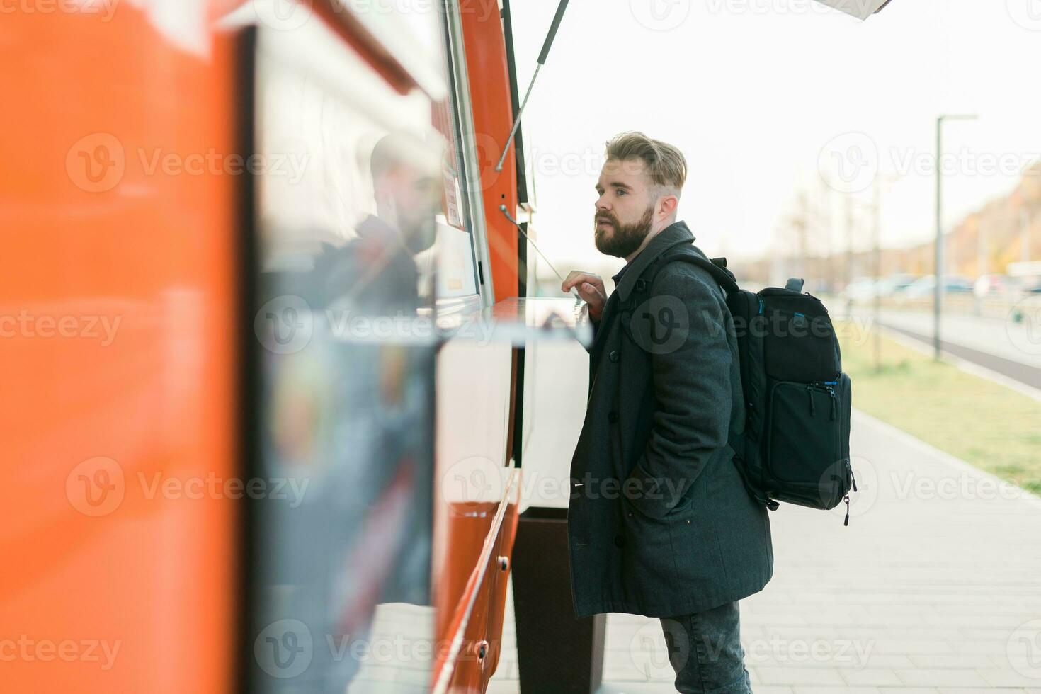 Portrait of man choosing fast food in food truck in the street. Meal, food industry and streetfood concept. photo