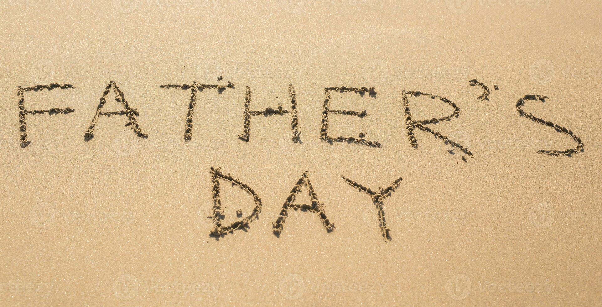 Father's Day hand written in the sandy beach in summer photo