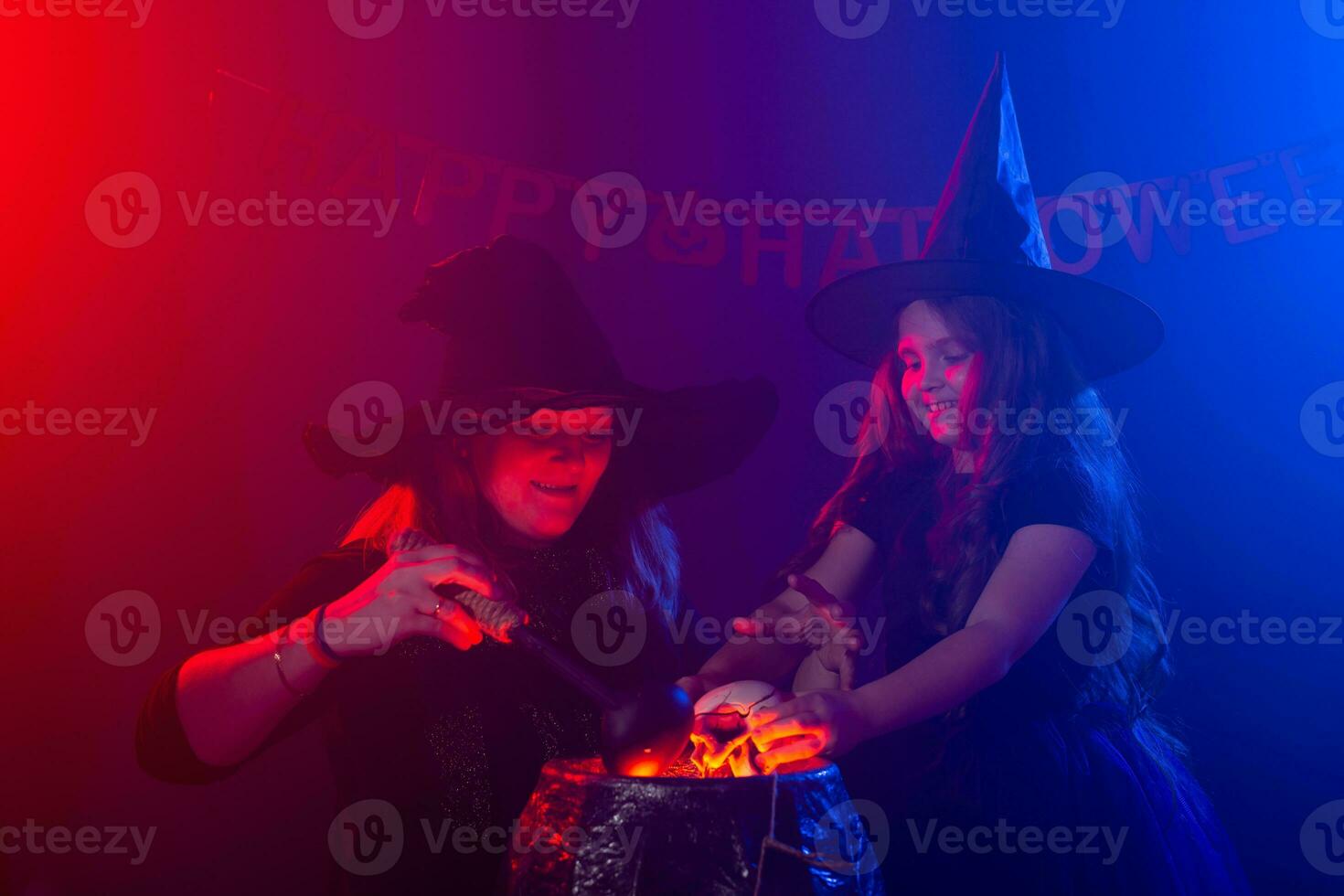 Funny child girl and woman in witches costumes for Halloween. photo