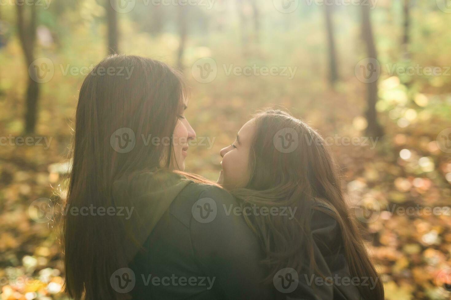 madre y hija gastar hora juntos en otoño amarillo parque. temporada y soltero padre concepto. foto