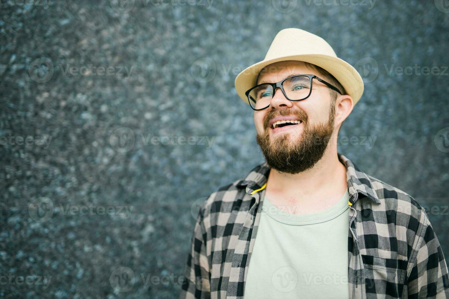 Handsome guy tourist looking happy wearing straw hat for travelling, standing against concrete wall background with copy space photo